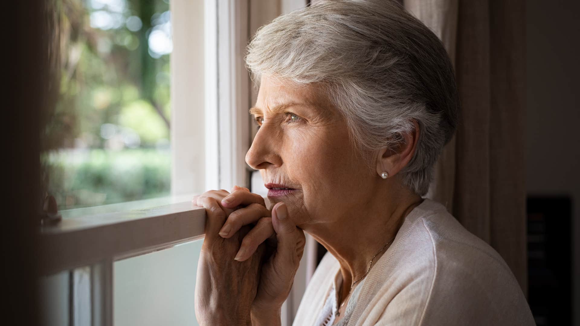 retired older woman sitting at home alone feeling lonely