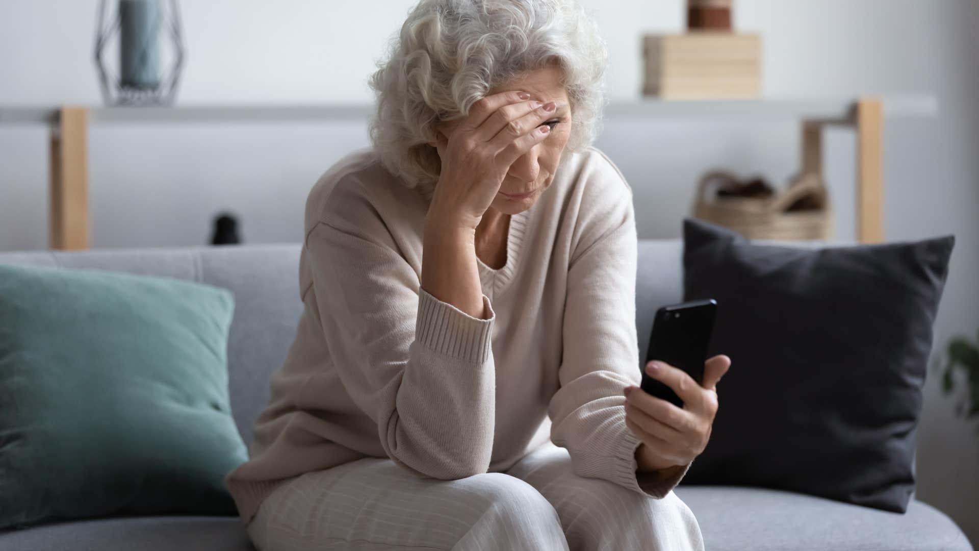 sad retired woman who feels like nobody needs her now looking at her phone