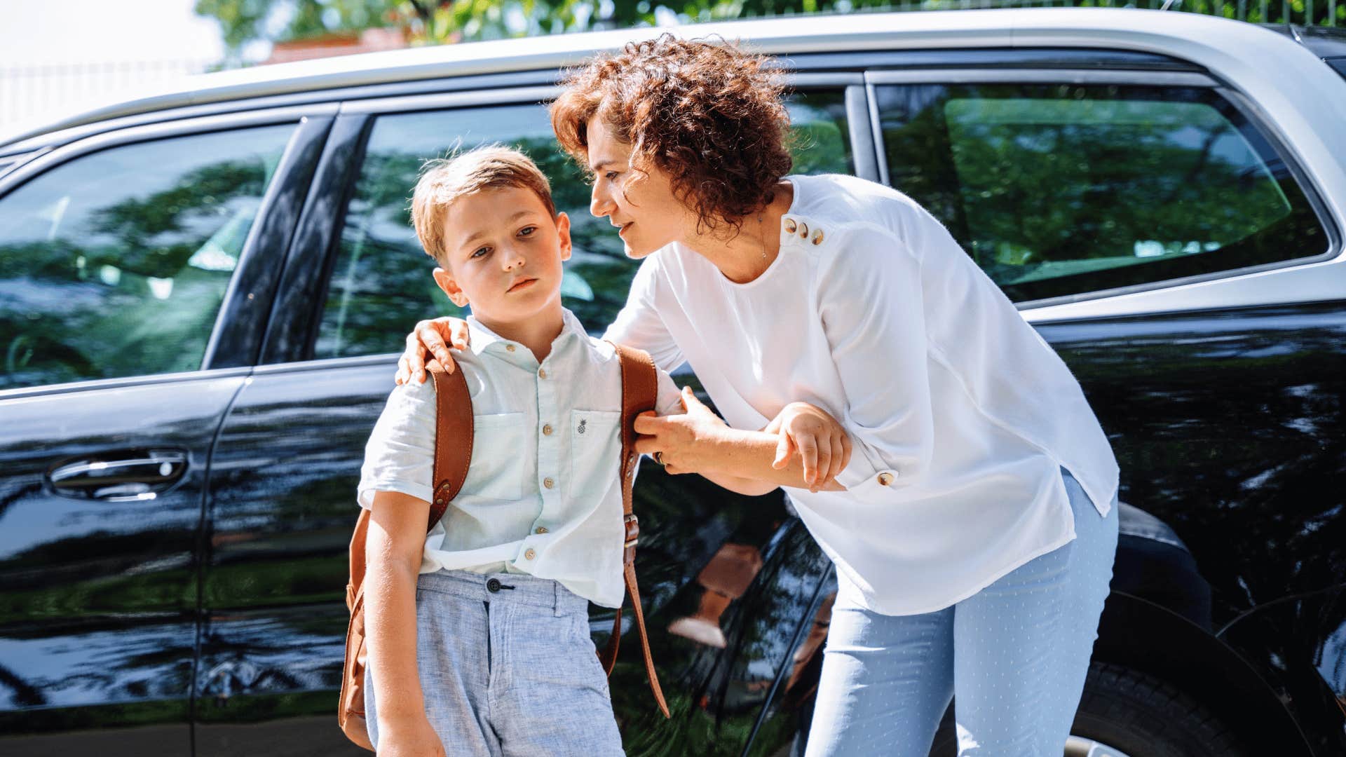 mom encouraging son dropping him off at school