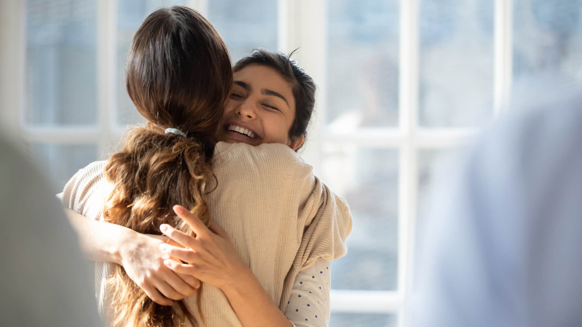 woman practicing gratitude thanking her friend and hugging her