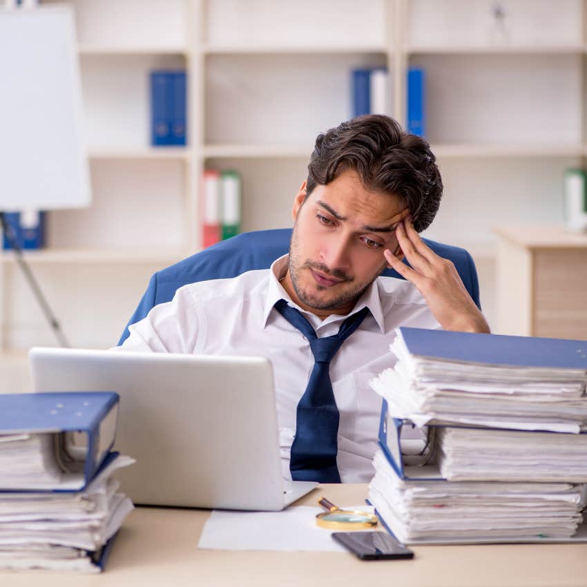 stressed employee with piles of work carrying too much responsibility