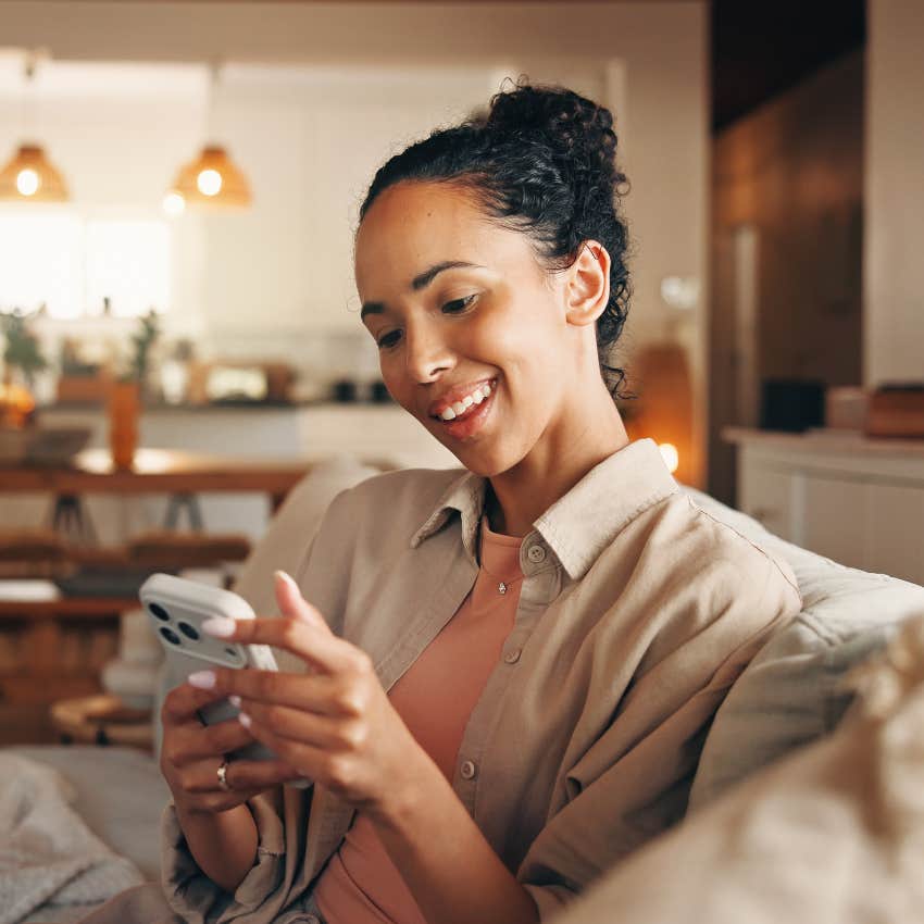 woman smiling reading text from reliable friend
