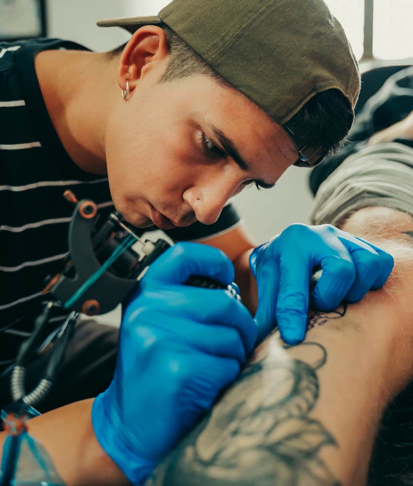 Tattooist tattoos man's arm