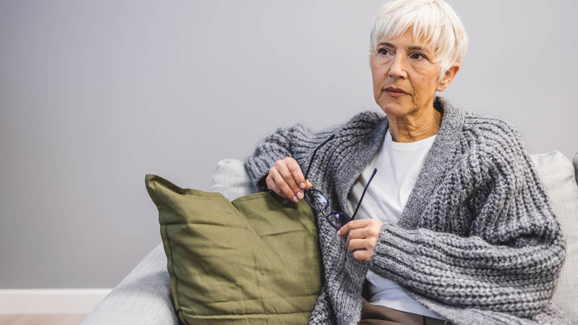 retired older woman sitting alone reminiscing about her old job