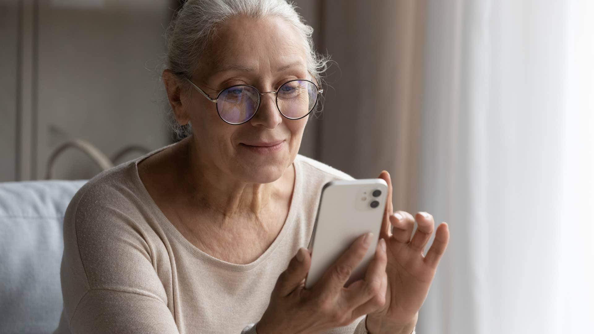retired older woman looking at emails on her phone