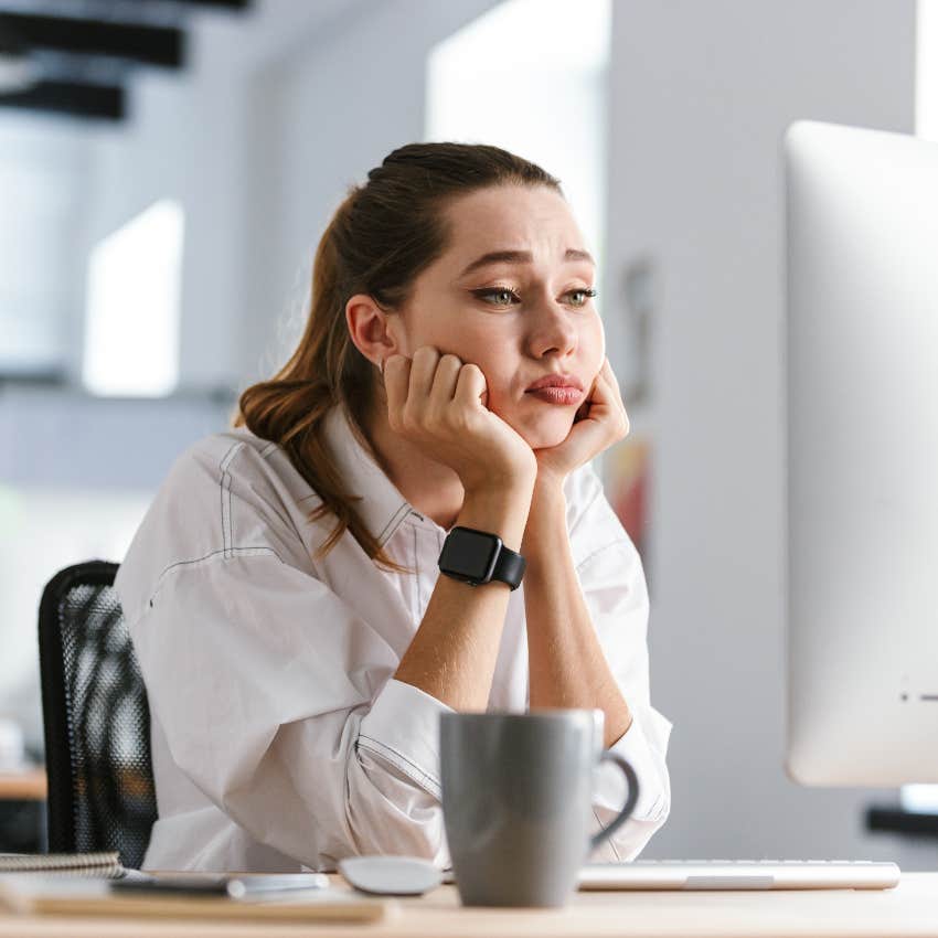 woman bored sitting at computer in office after return to office mandate