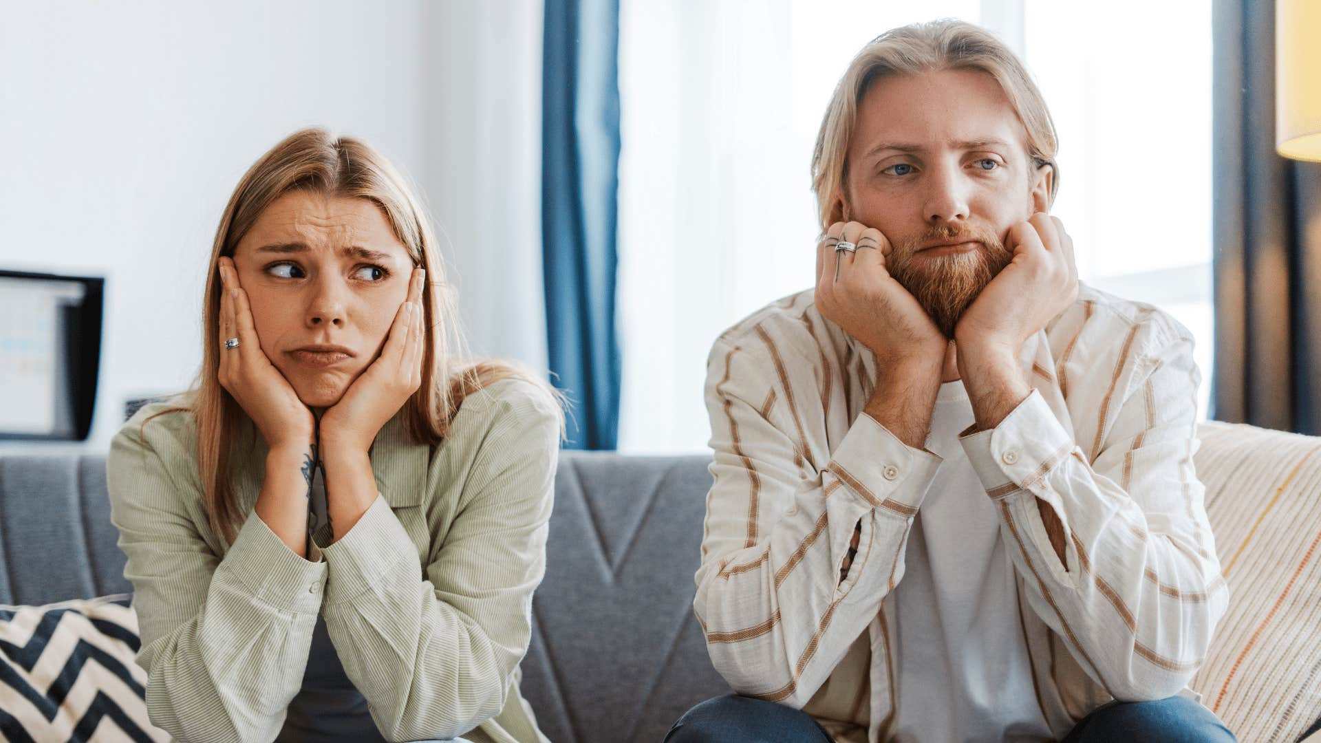 miserable couple sitting next to each other feeling emotionally drained