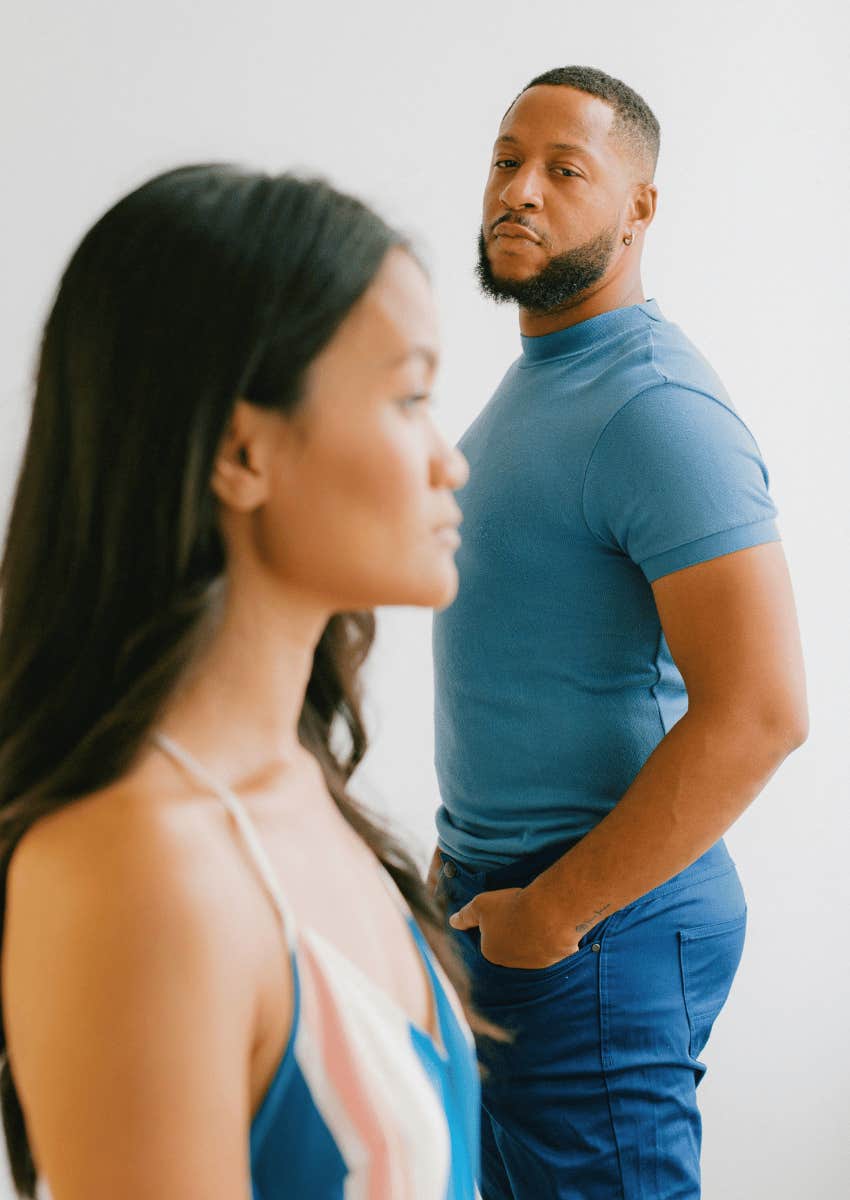 serious man staring at woman across a room