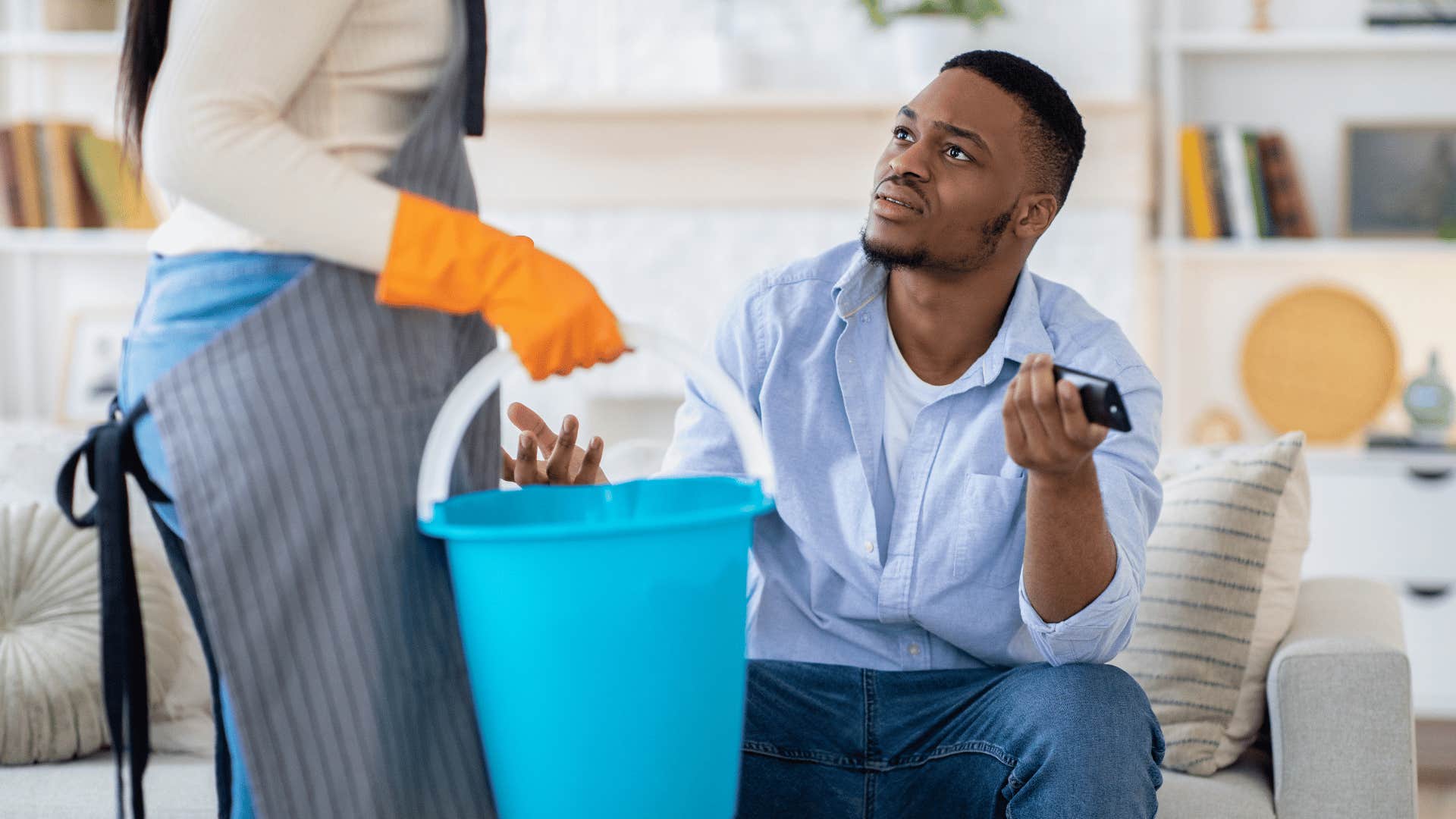 man waiting to do chores until his wife watches him