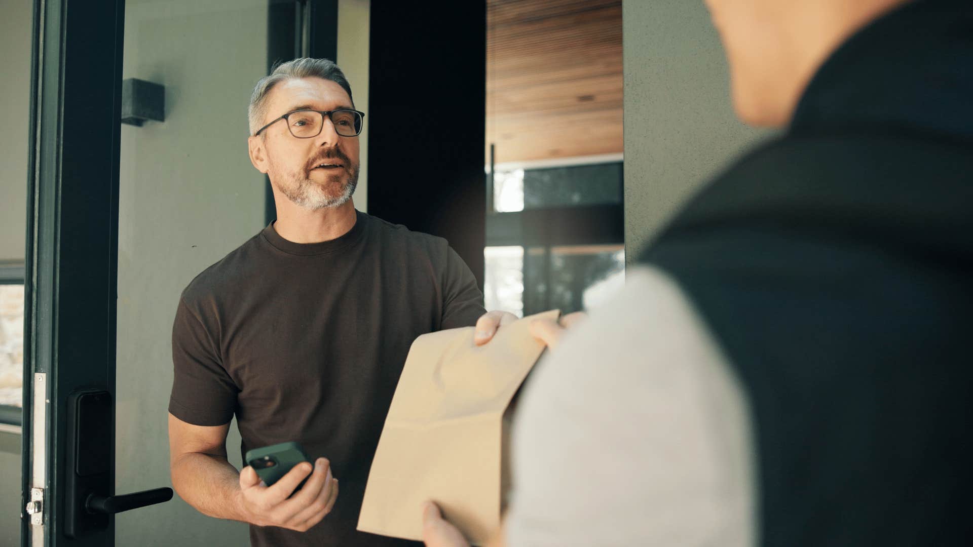 man accepting takeout from delivery driver