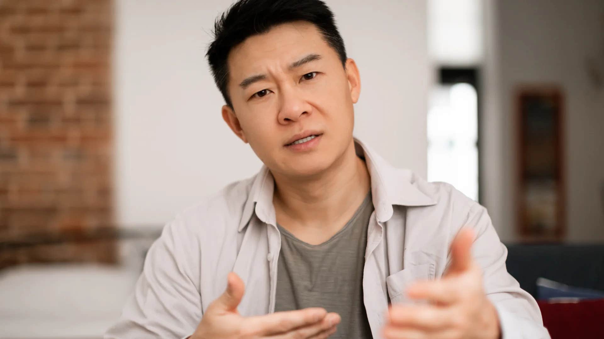 man annoyed explaining to friend why saying it's just a joke is offensive