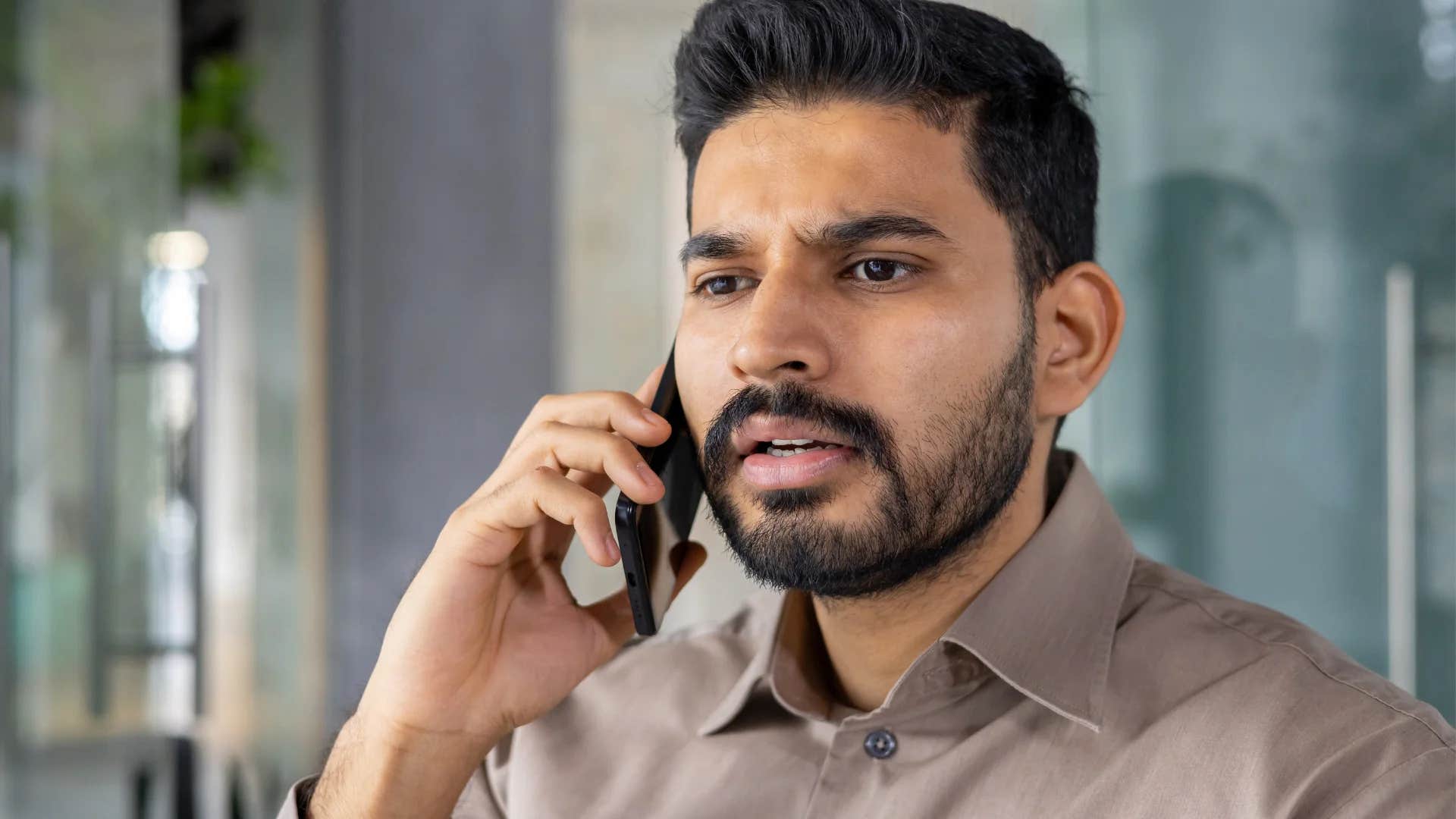 smart man on the phone feeling deeply offended by friend saying that's not my fault