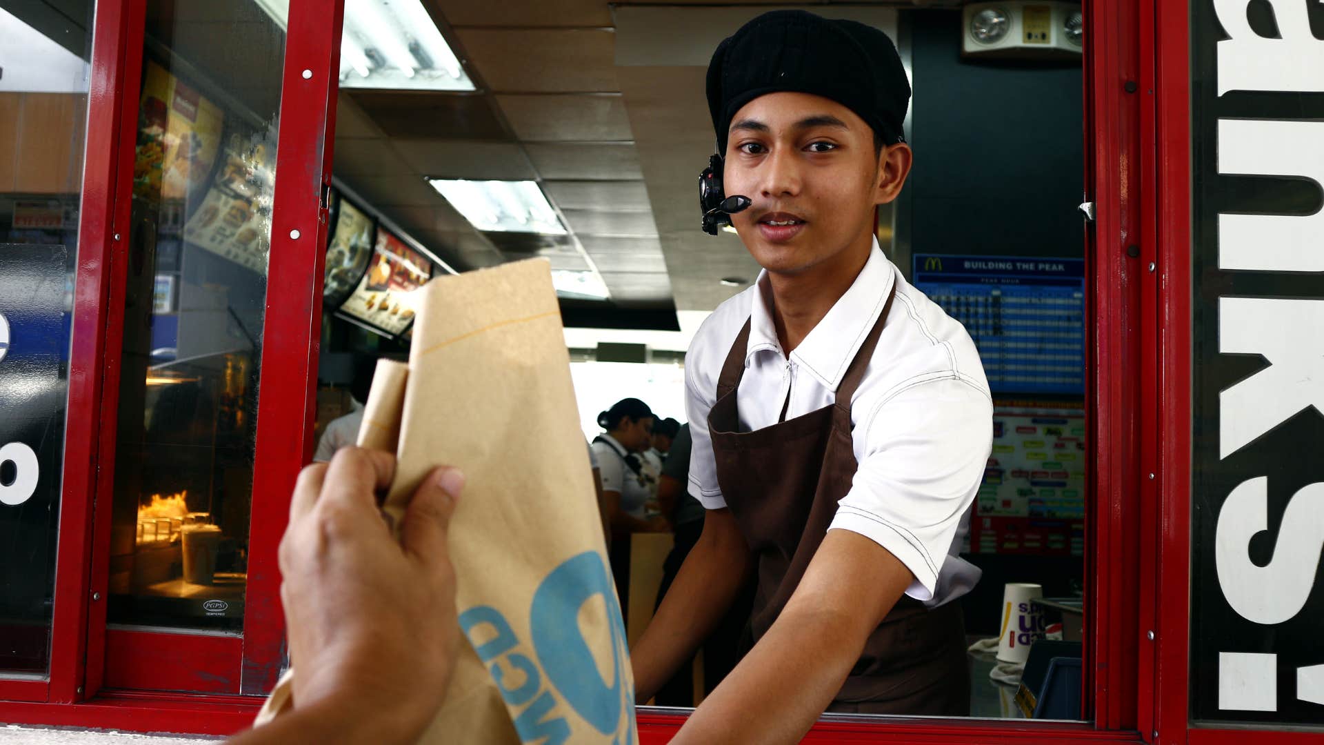 drive thru worker handing man his food providing fast service
