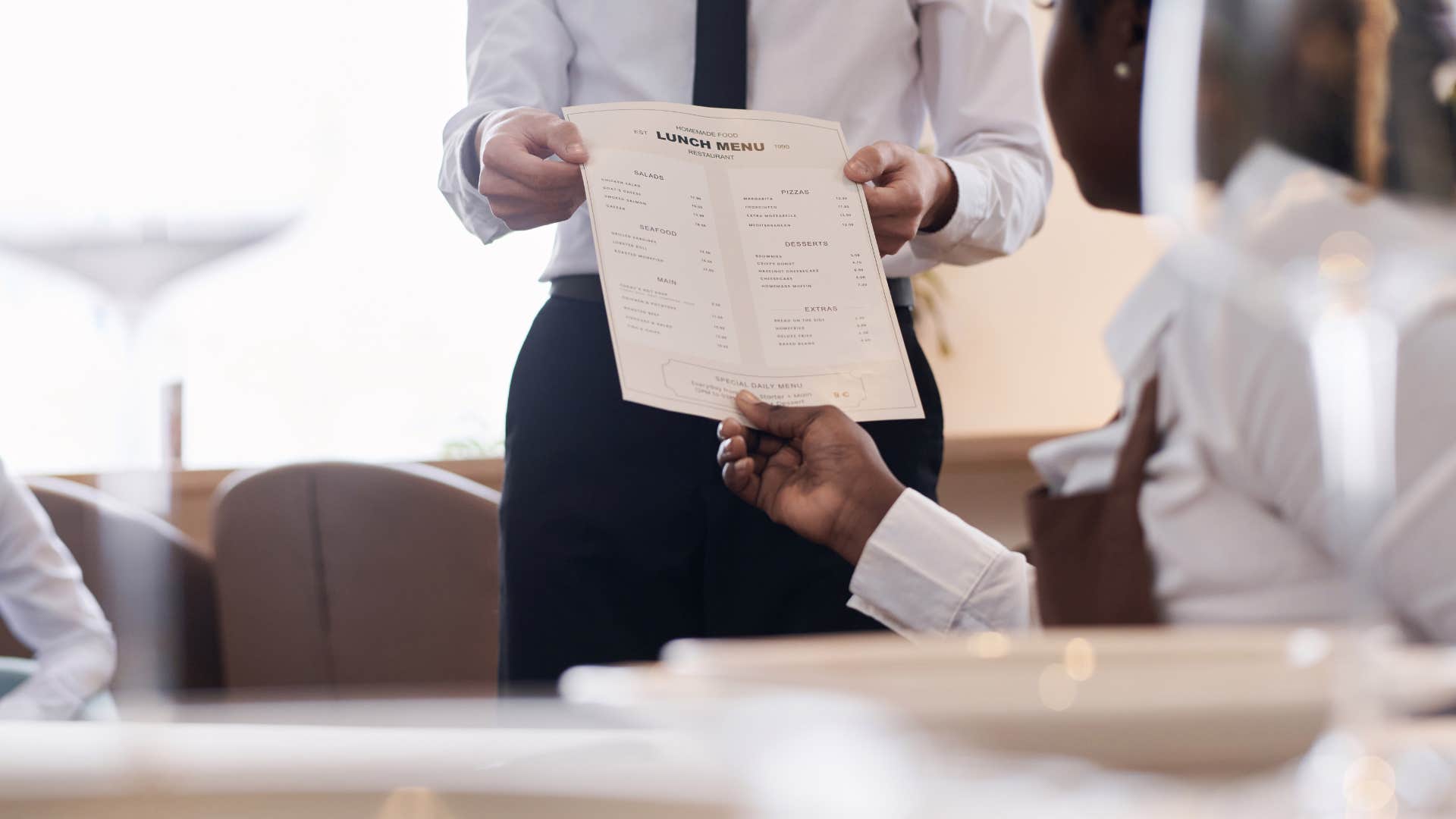 waiter handing menu to customer