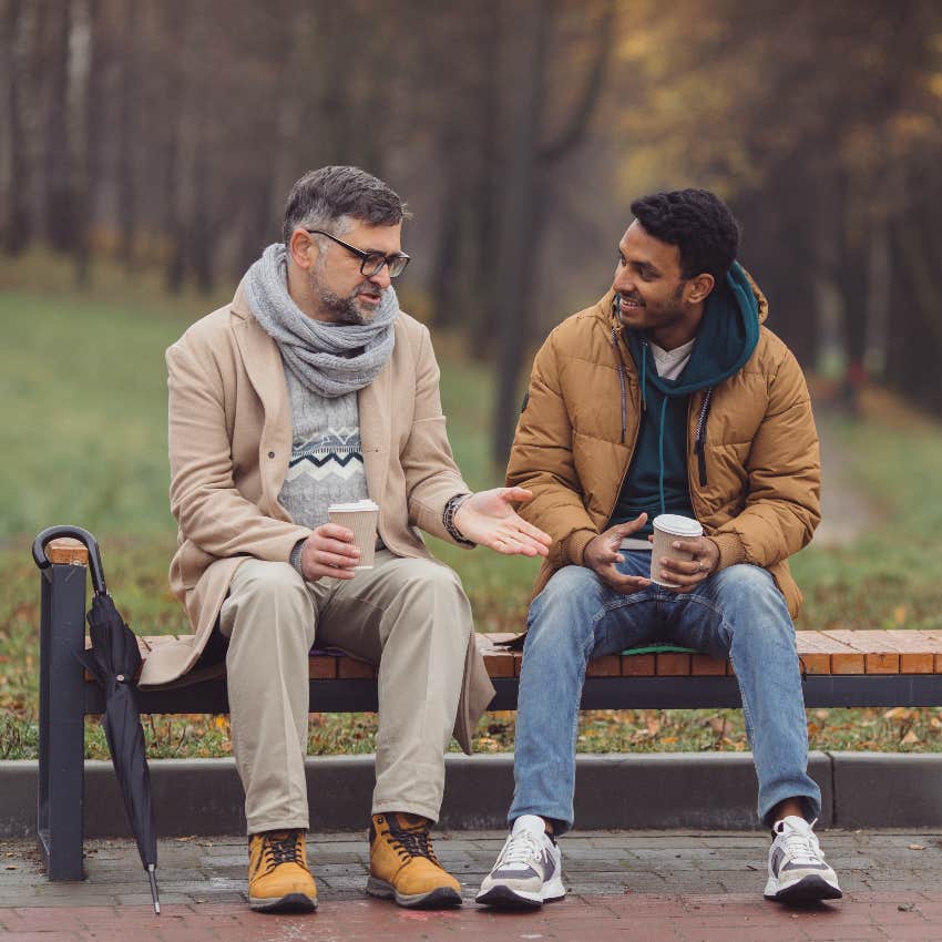 two men making small talk sitting on bench