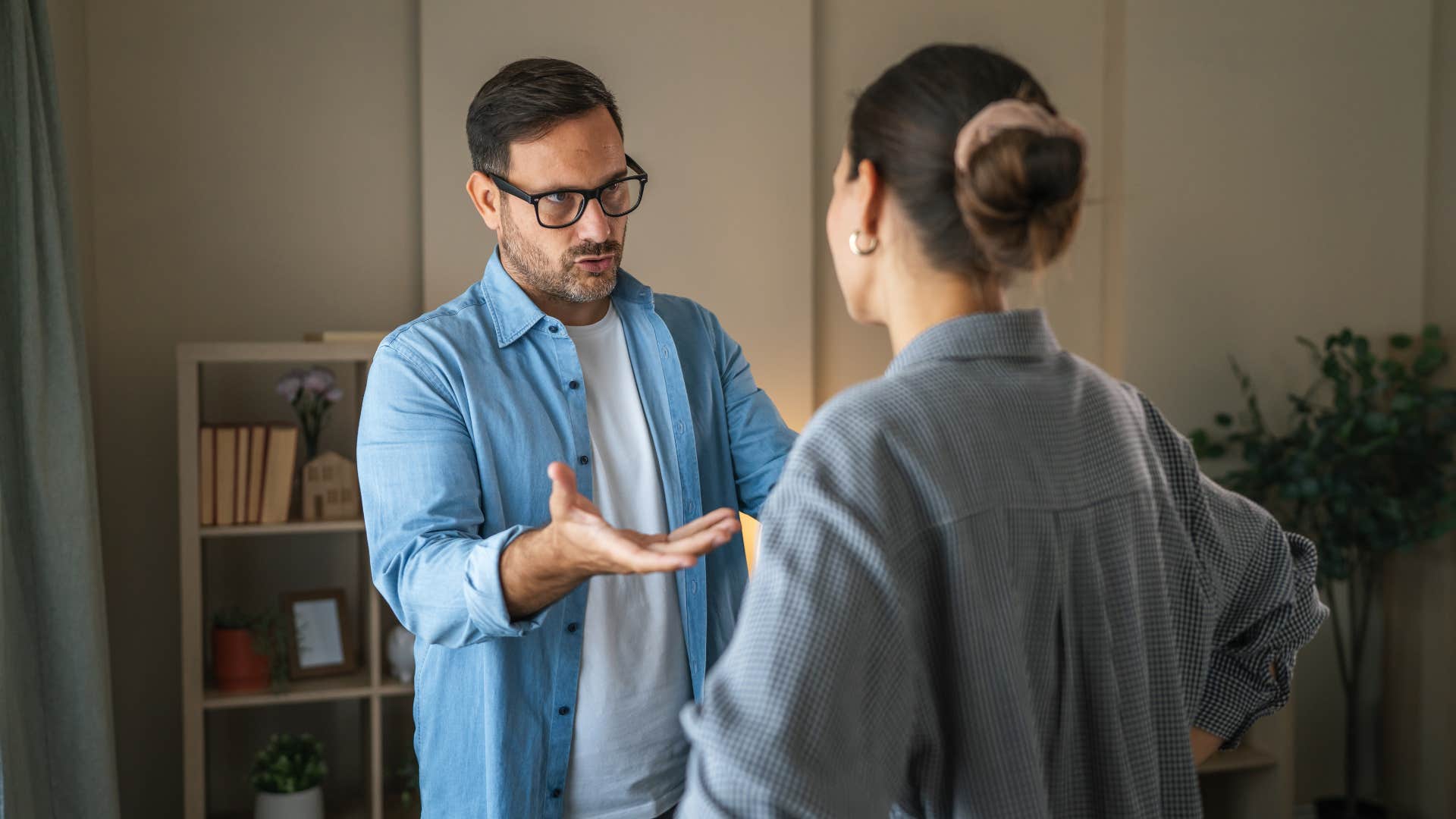 husband having tense conversation with wife at home