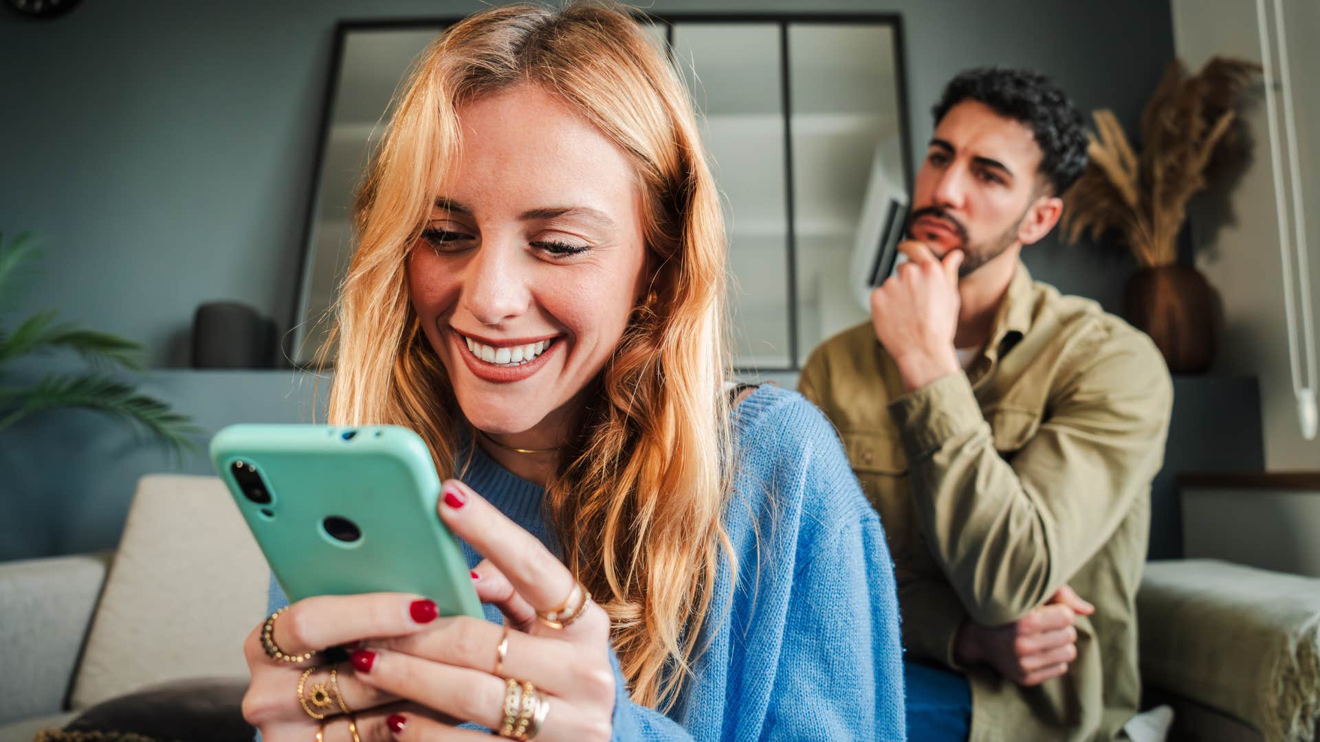 husband looking jealous at wife using her phone