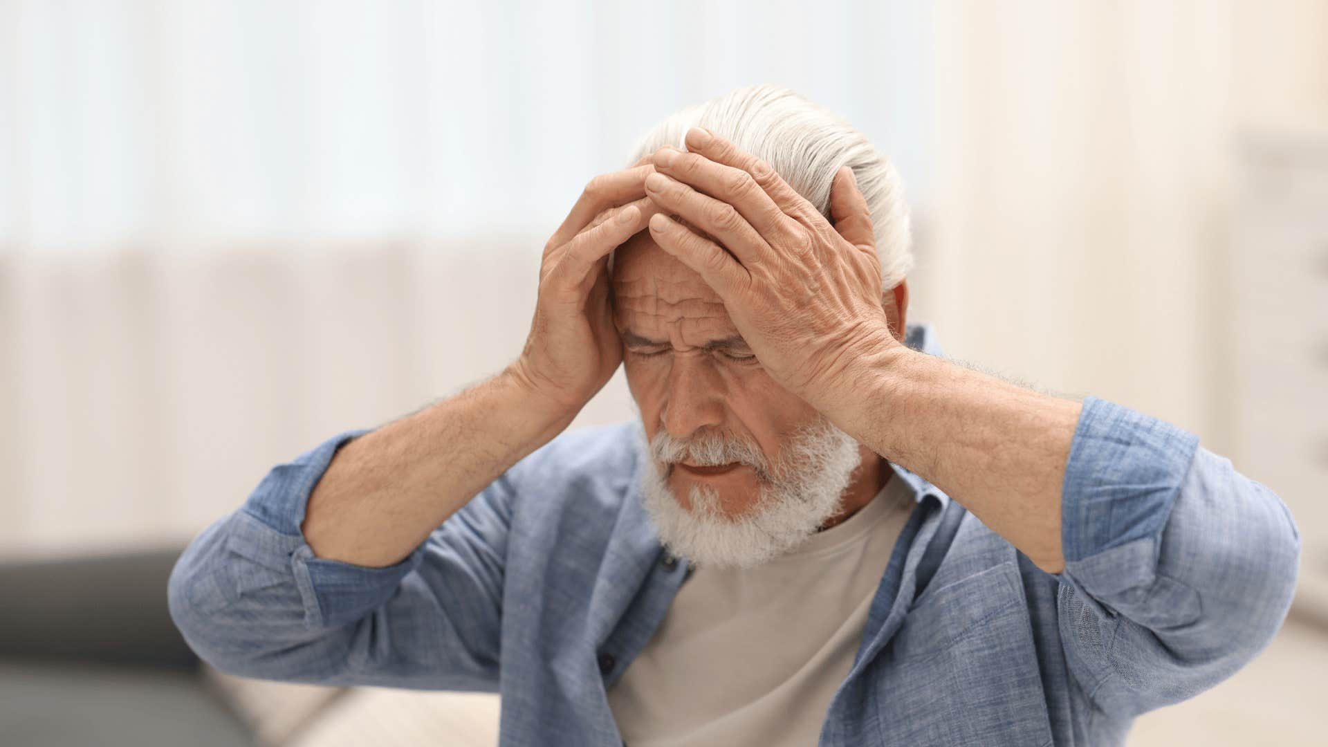 man in blue jacket saying my brain isn't working properly as he clutches at head