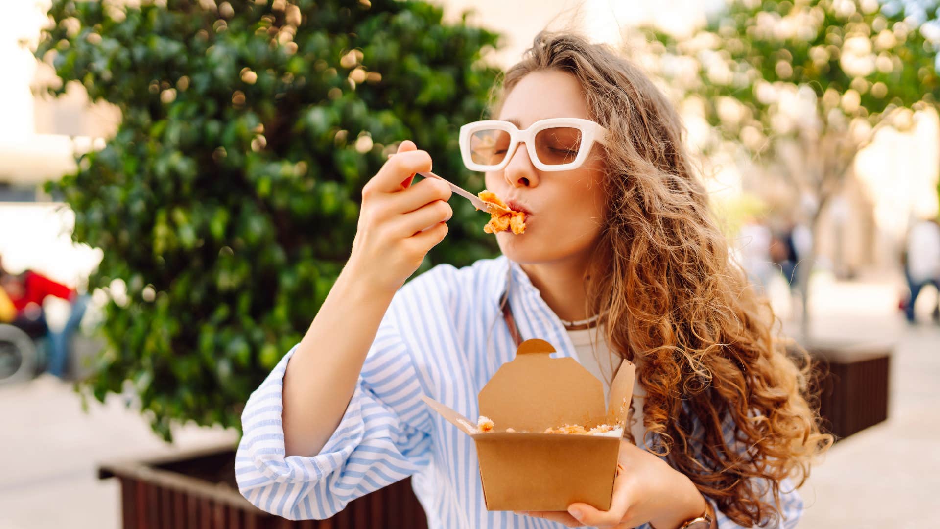 woman enjoying food as someone asks if she's really going to eat all of that