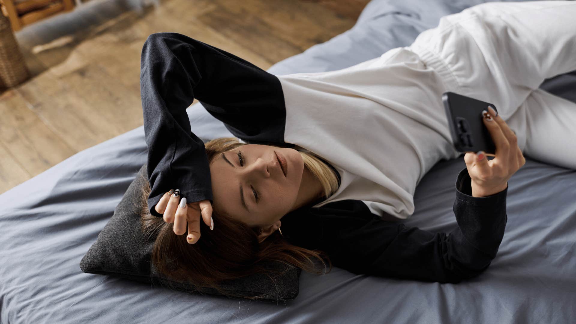 sad woman looking at phone instead of doing self-care