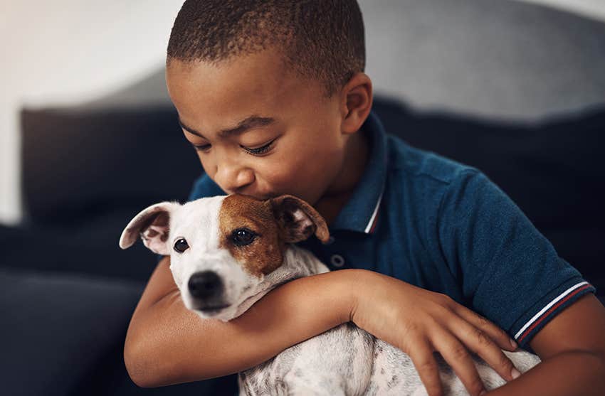 young boy speaking baby-talk to a puppy