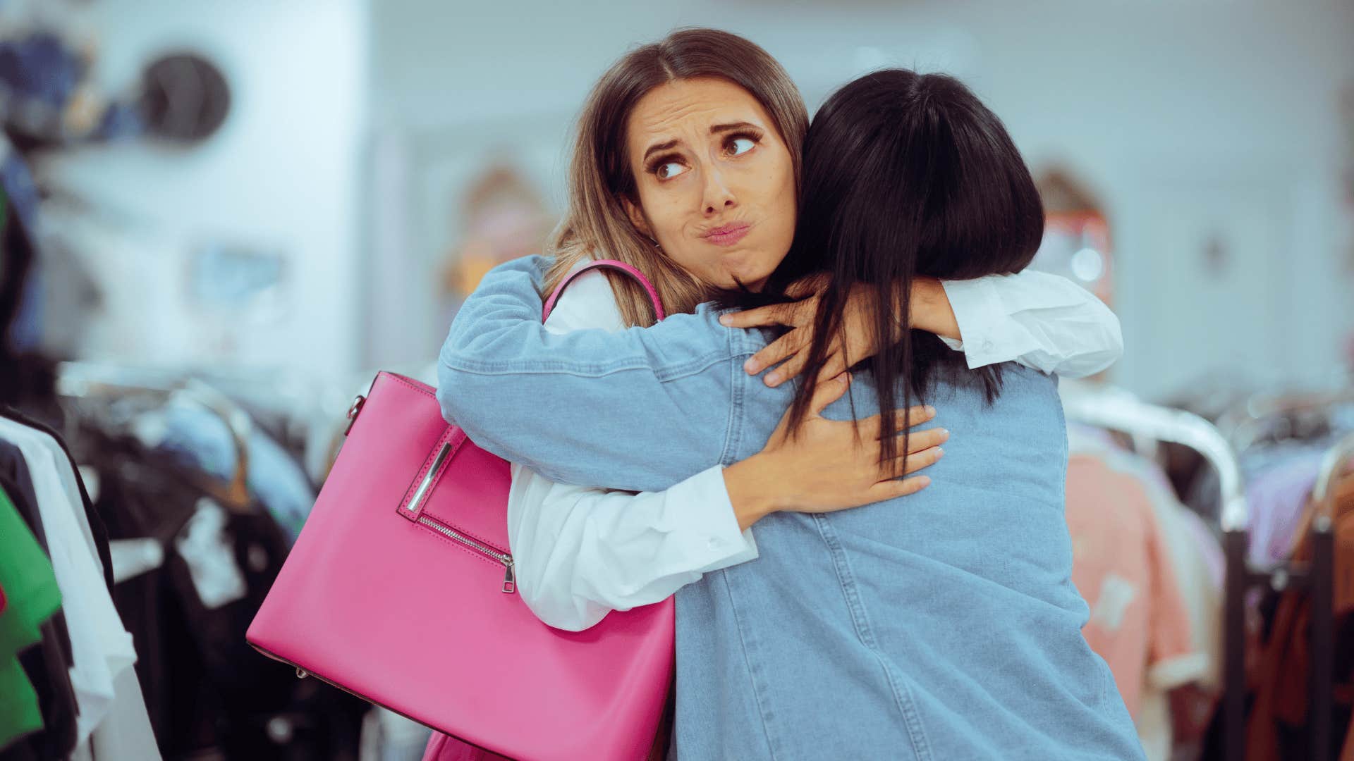 introverted woman reluctantly hugging friend who is ignoring her boundaries