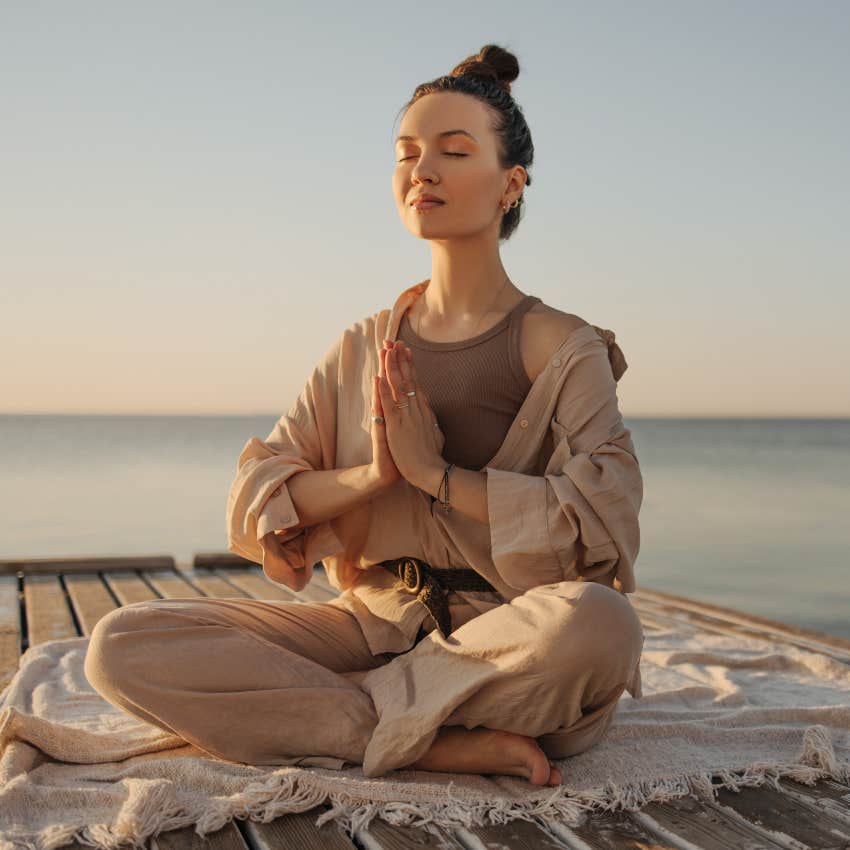 woman meditating on a pier