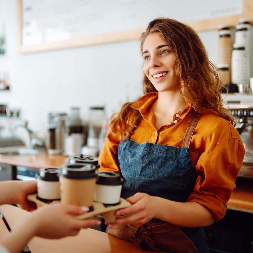 female barista handing coffee cups to customer