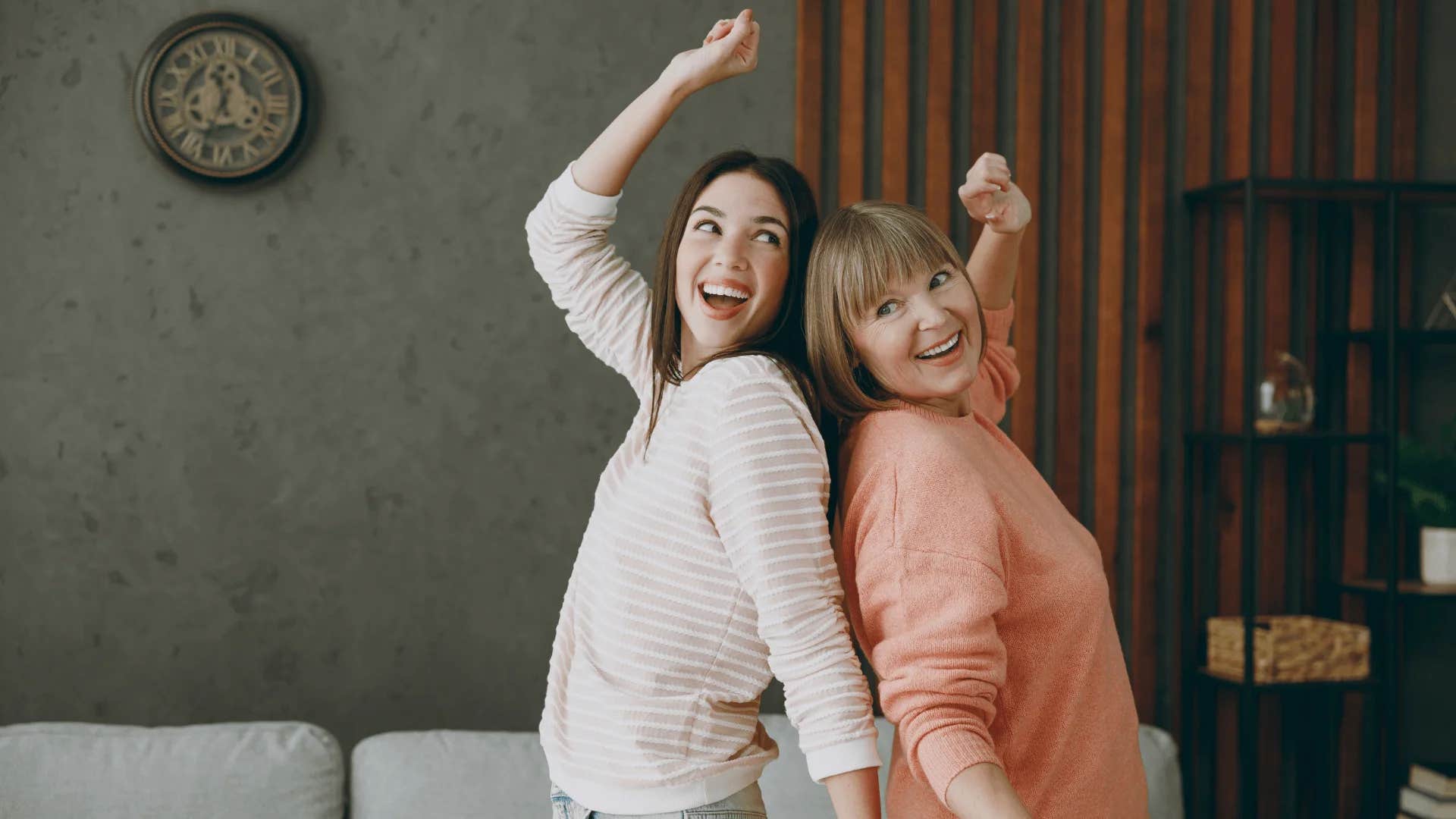 mom and adult daughter dancing around the house