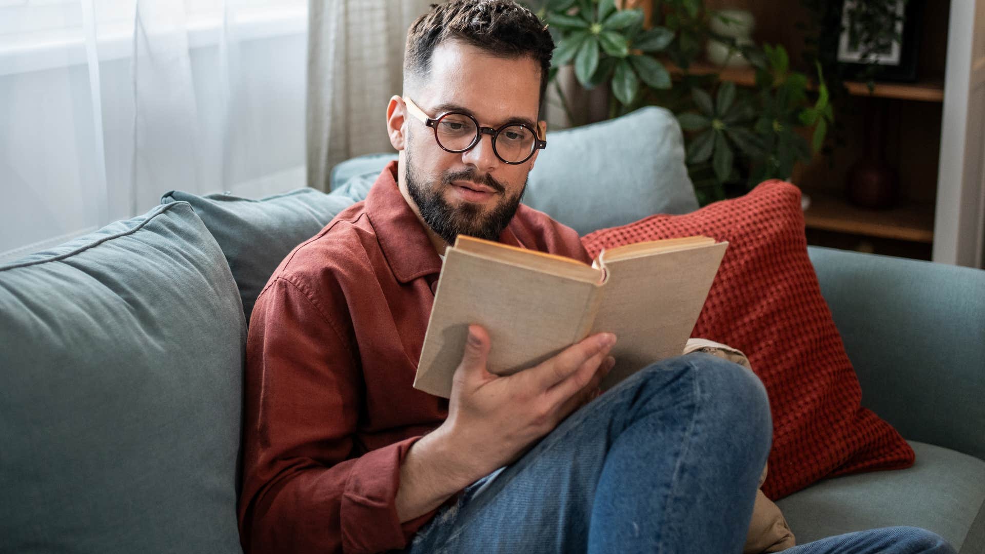 man doing a digital detox and reading a book at home