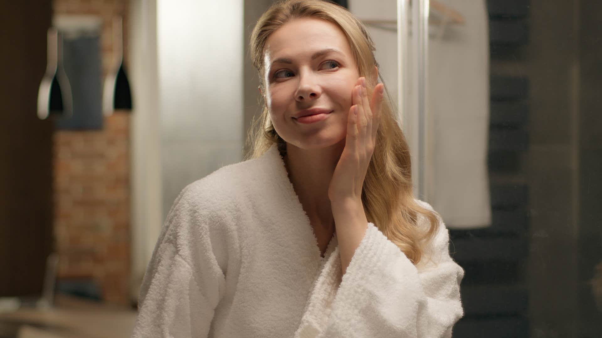 woman applying skincare products after taking a mindful shower