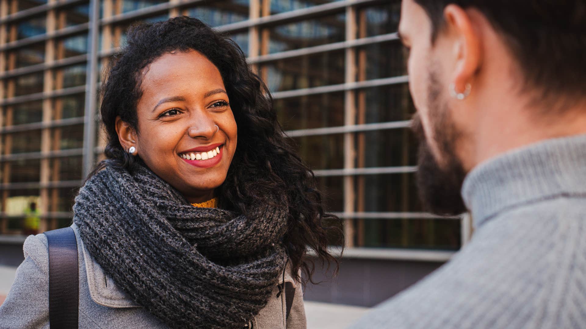 woman actively listening to man speak to her outside