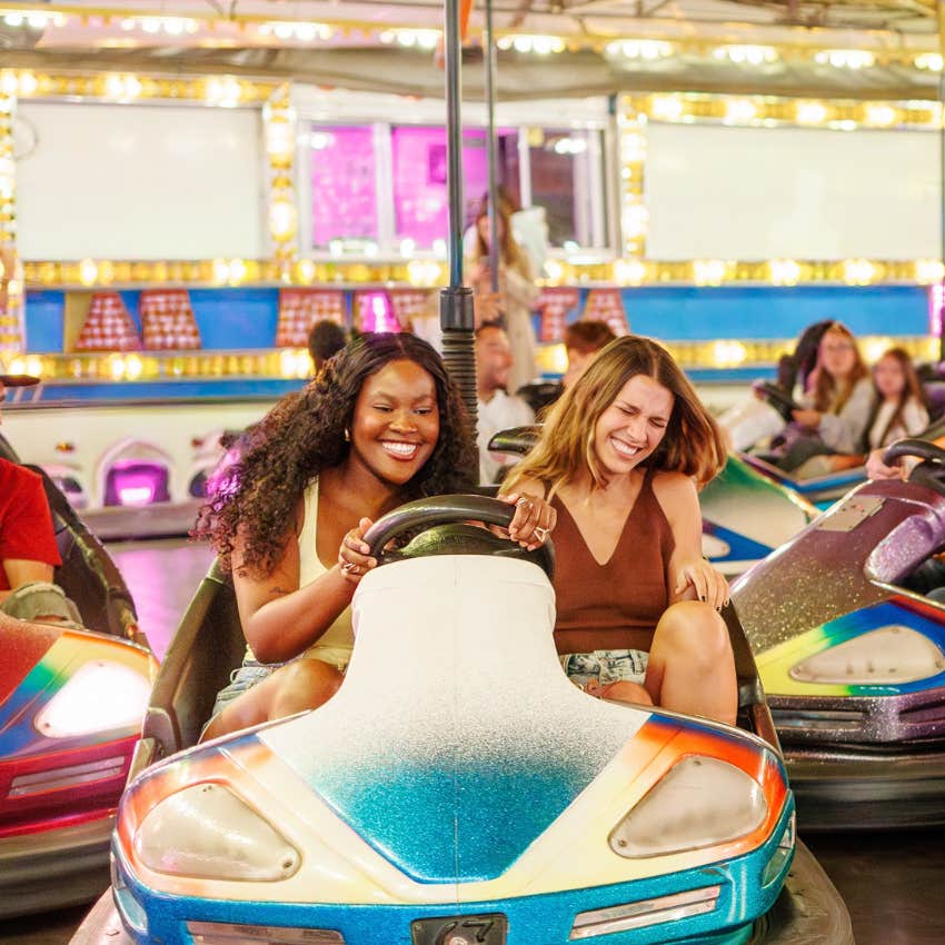 two friends having fun on bumper cars making time to focus on their well-being