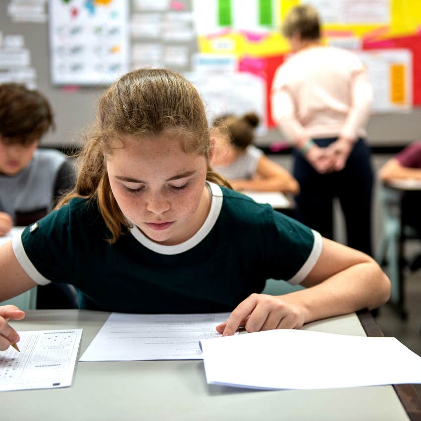 high school student taking test in classroom