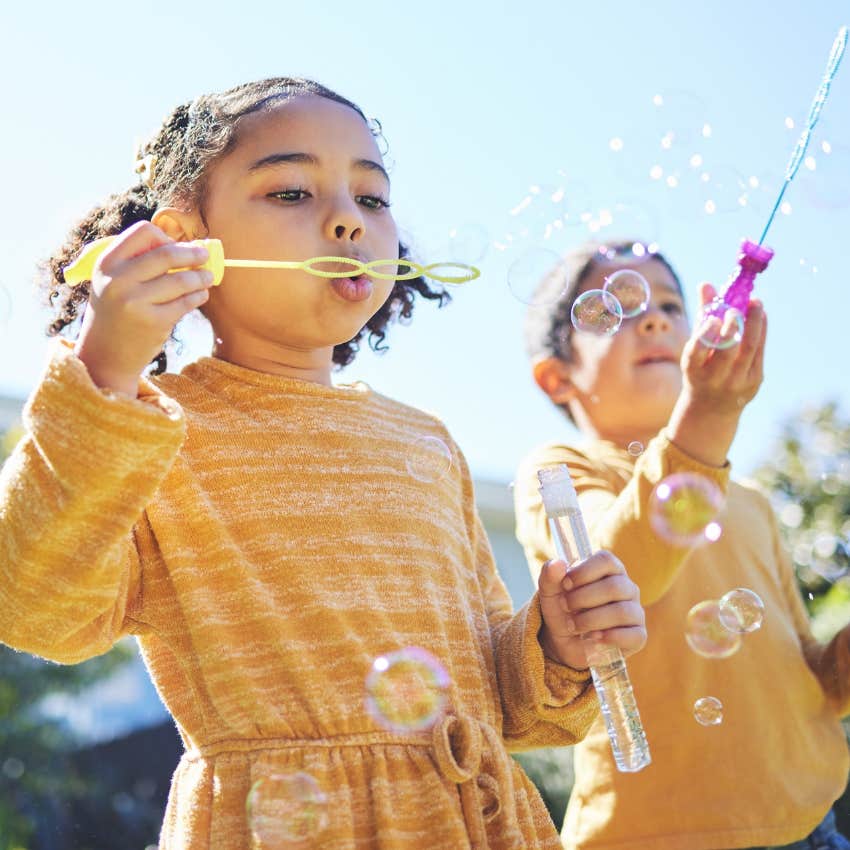 kids blowing bubbles playing outside