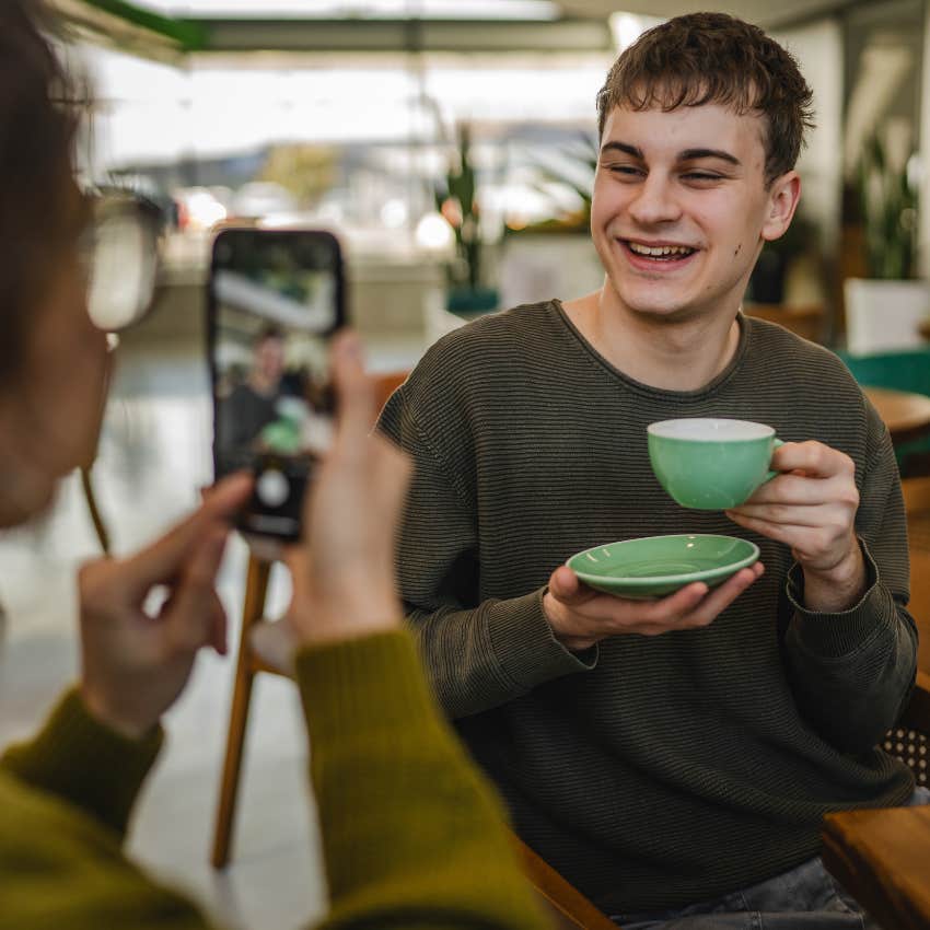 woman taking a photo of man in his favorite restaurant