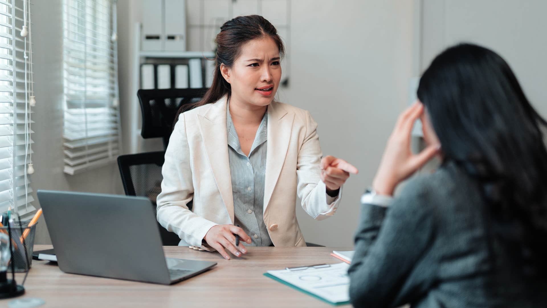 boss reprimanding employee pointing at her