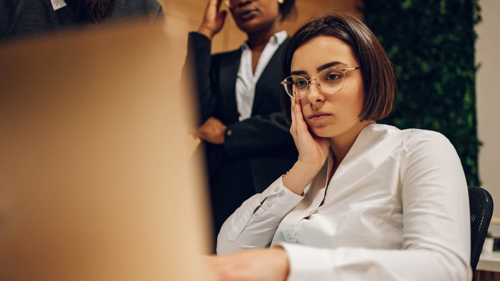 annoyed woman sitting in front of computer in meeting