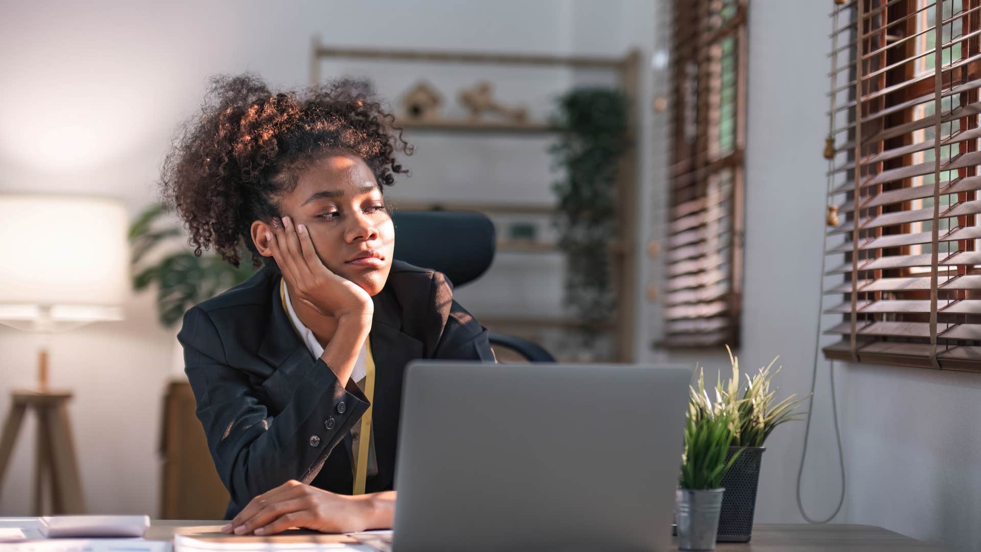 high iq exhausted woman sitting at desk looking tired