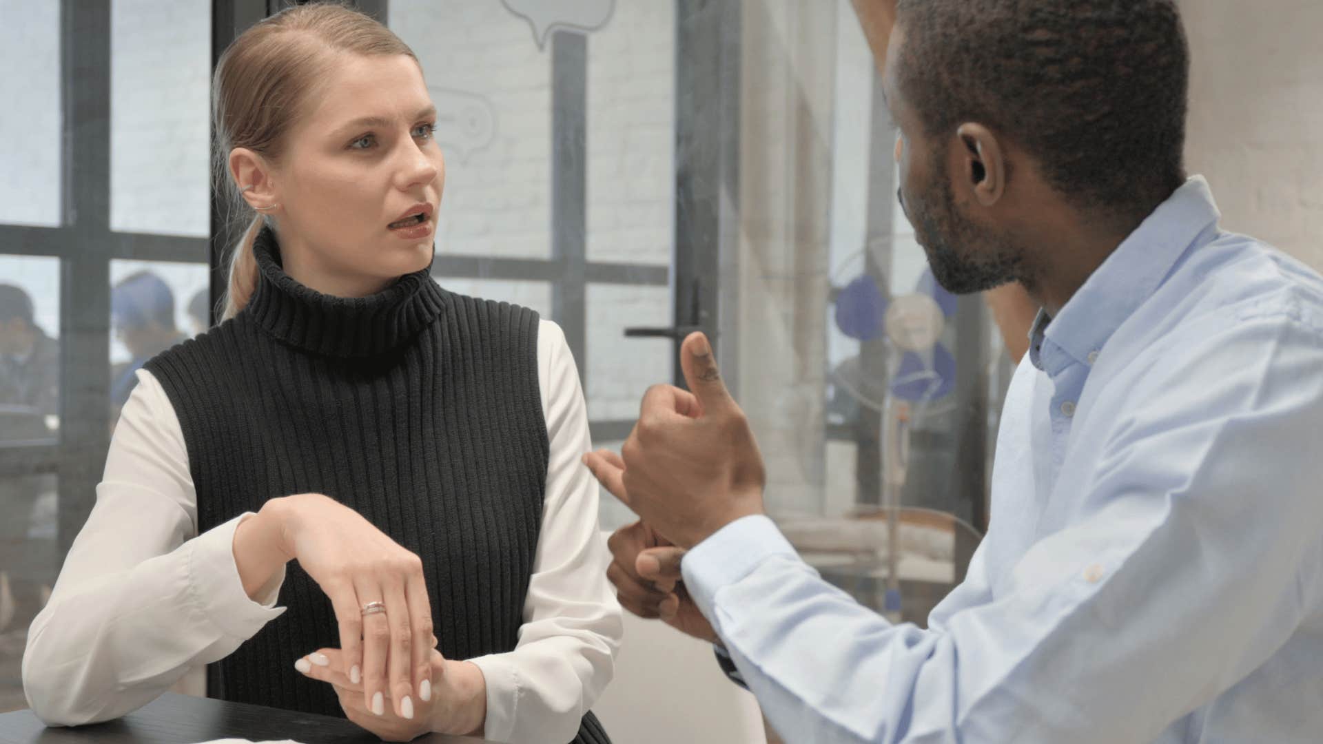 Woman talking about assumptions with her co-worker.