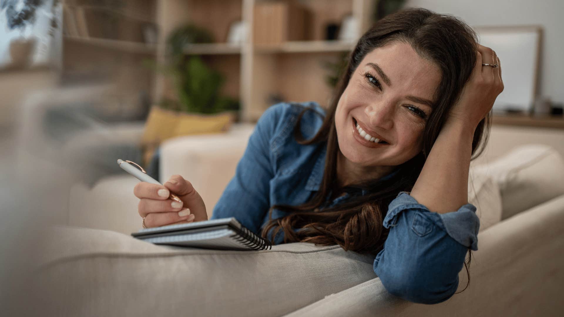 Woman journaling about internal patterns at home.
