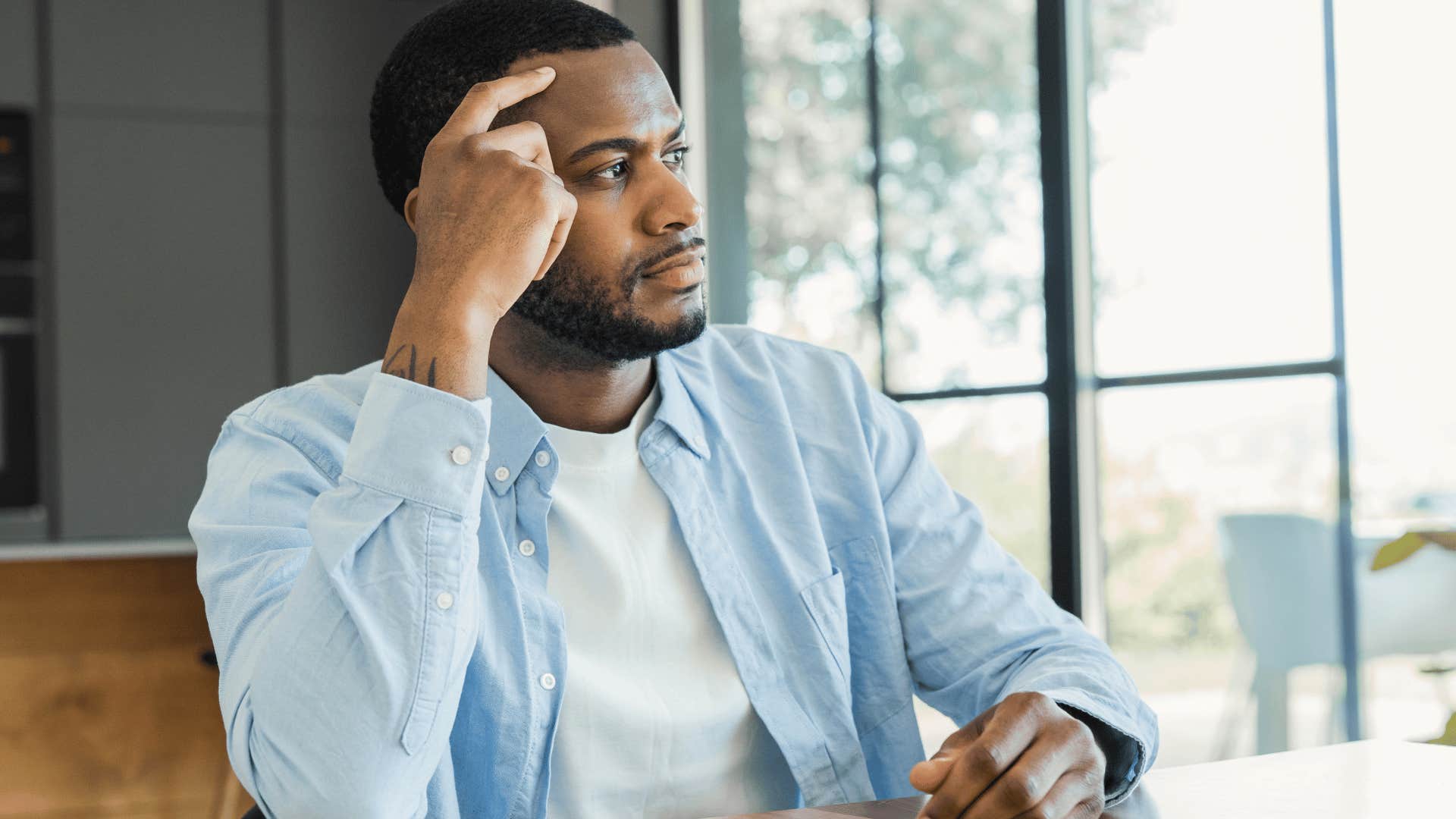 Man thinking about something that feels unnecessarily complicated at home.