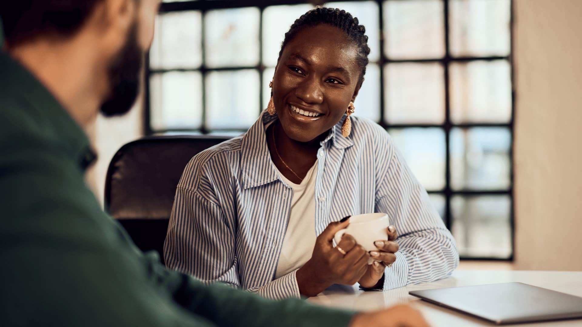 high-value woman noticing her co-worker's questions and smiling