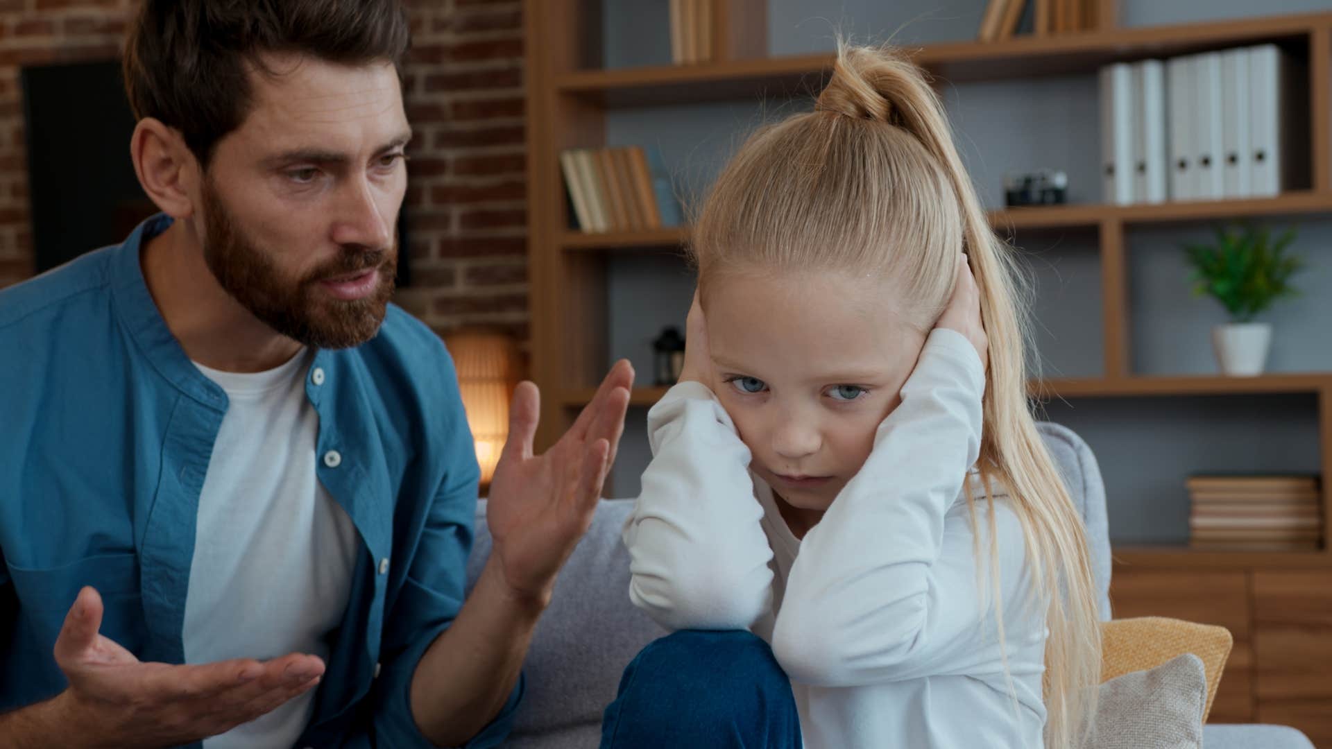 man disciplining his child while having guests over