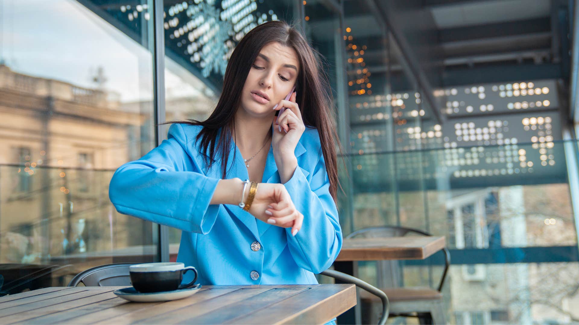 woman looking at her watch while on the phone in a draining conversation