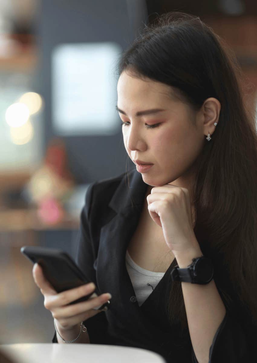 thoughtful woman scrolling on her phone