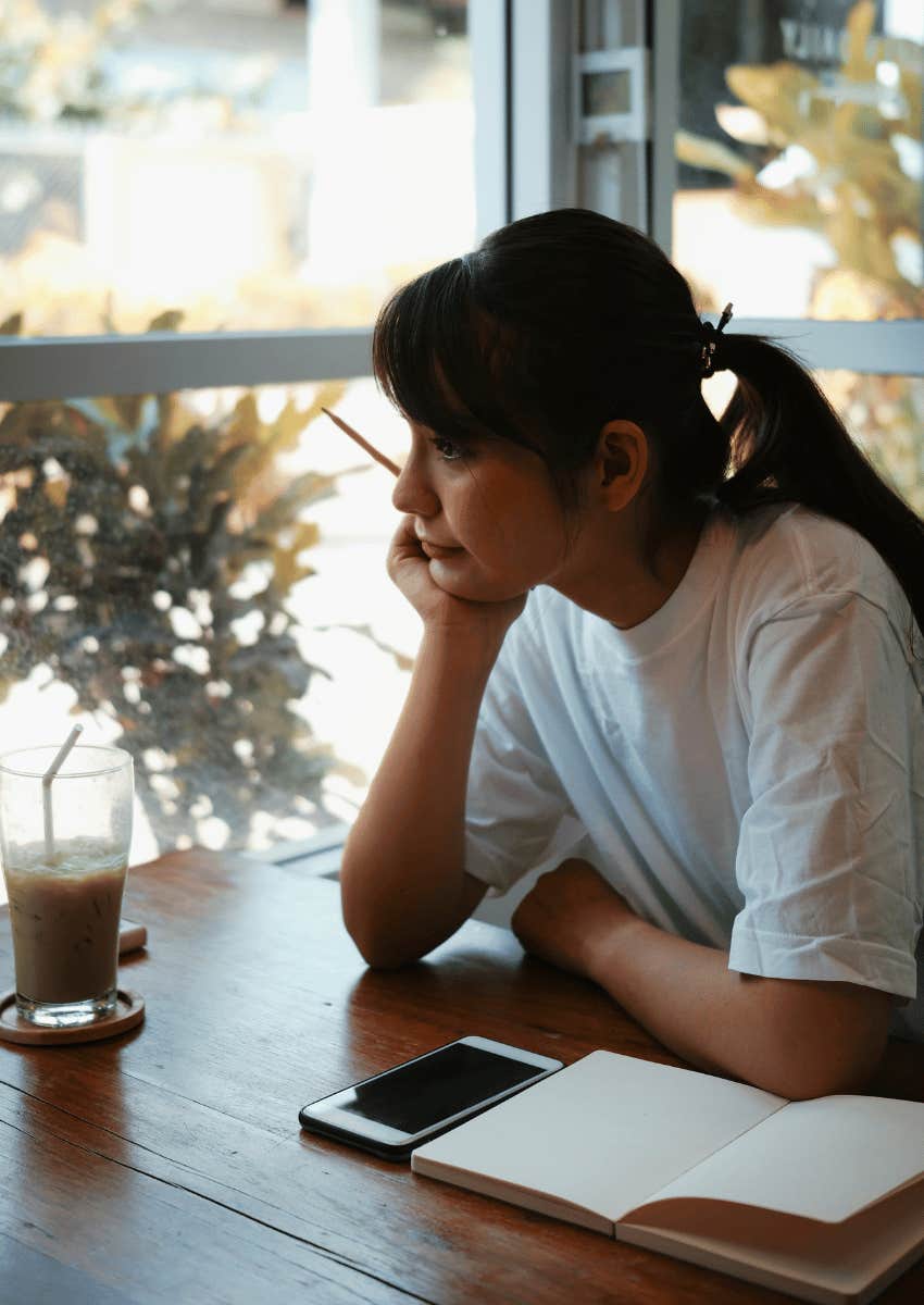 thoughtful young woman looking out of window