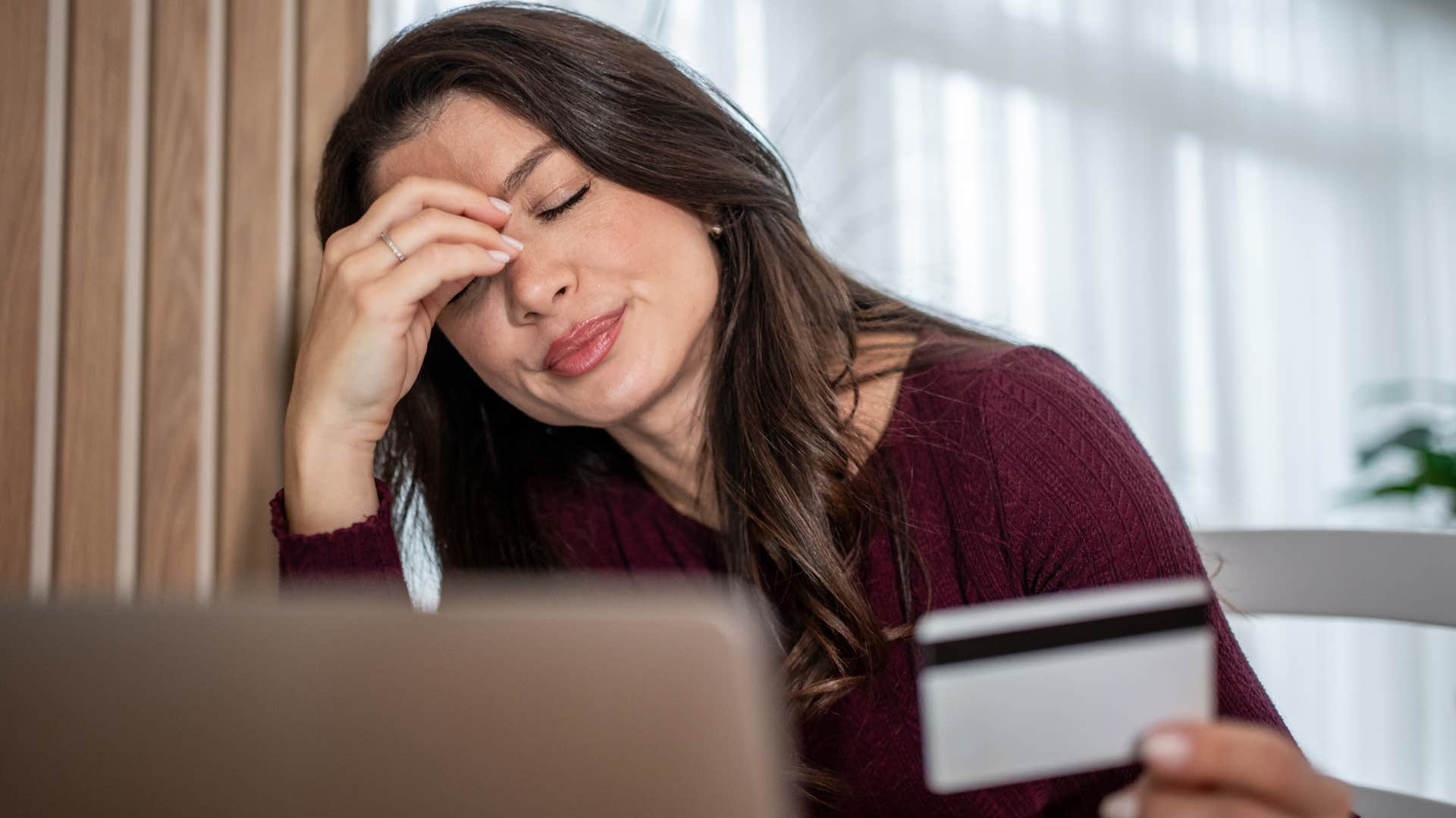 woman who's financially irresponsible holding her credit card
