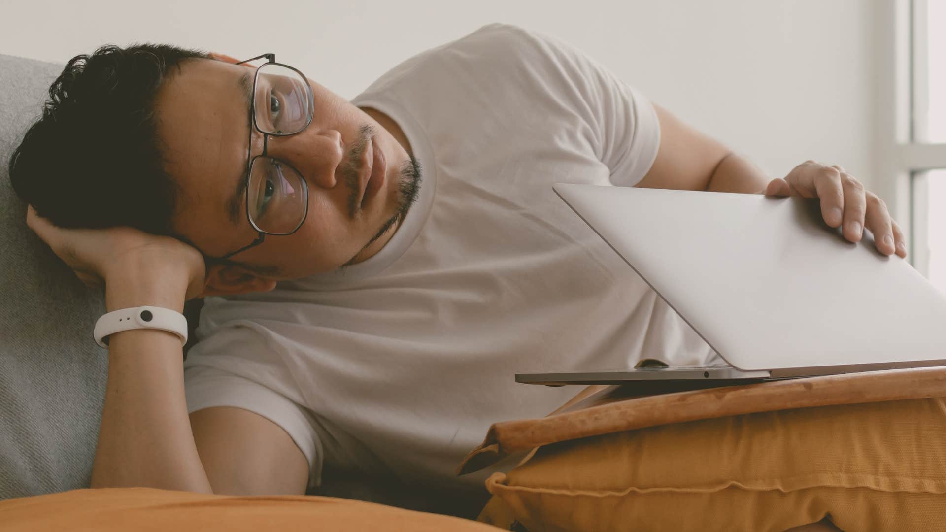 man feeling bored alone at home on his computer