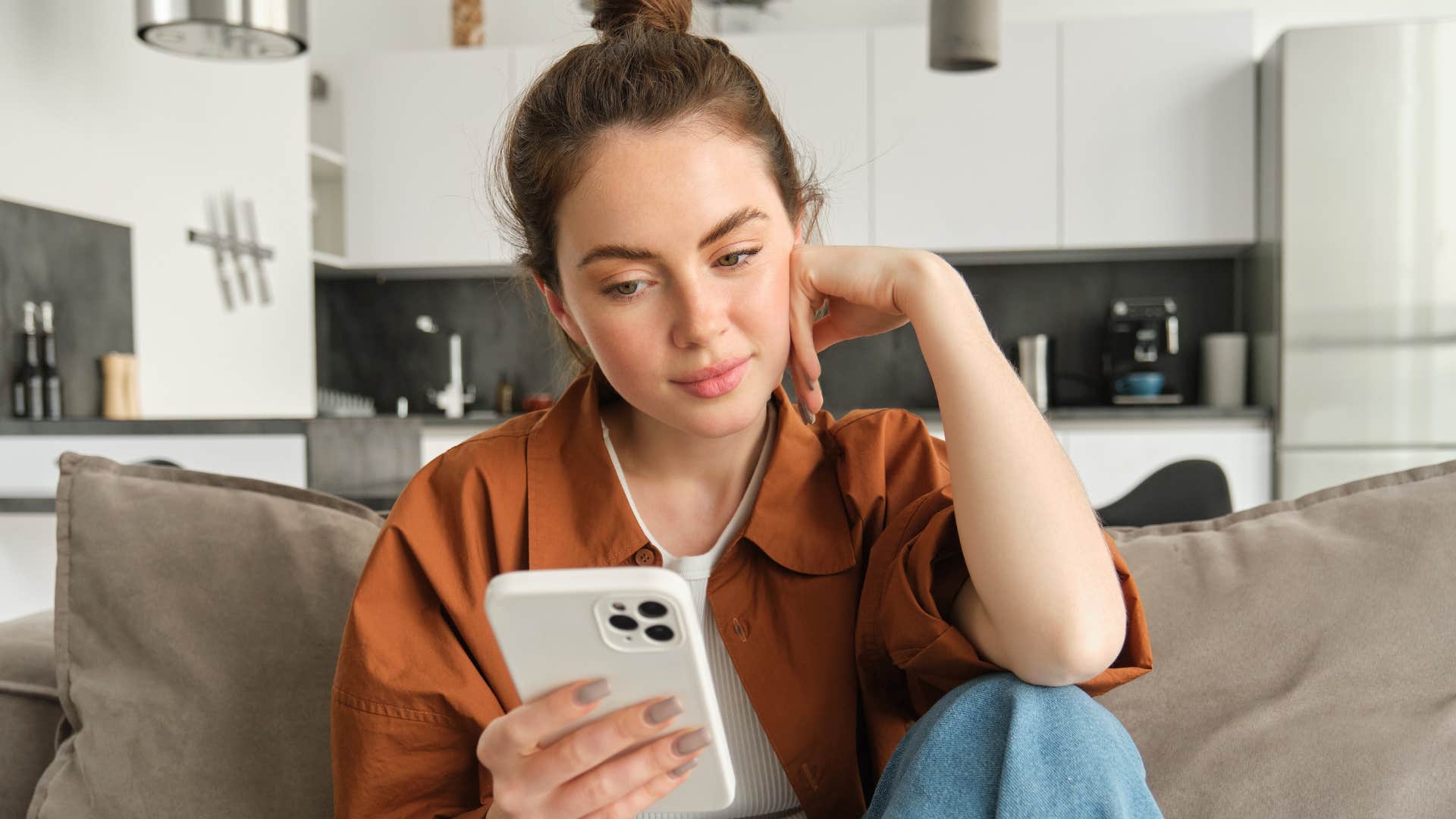 introverted woman looking at her phone after being left on read